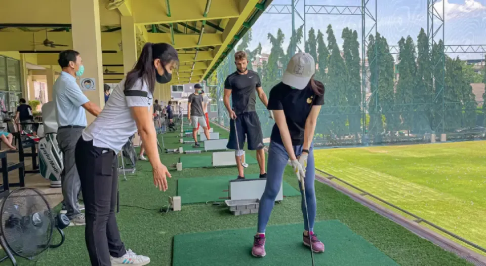 Beginner golfer taking first golf lesson in Bangkok