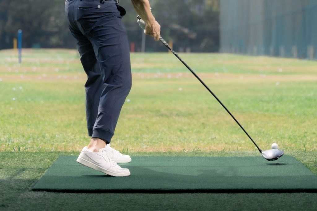 A golfer preparing for Bangkok's tropical climate with proper golf gear and hydration.